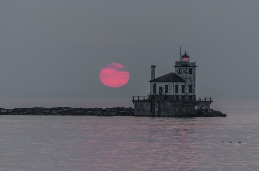 Aerial panoramic view of the Lake Ontario shoreline and Oswego Harbor lighthouse amid U.S. and Canada bilateral maritime boundary debates.