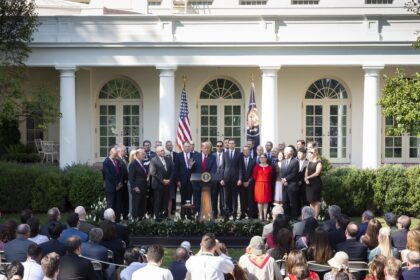 President Donald J. Trump speaks before press corps and broadcast microphones during a White House press briefing