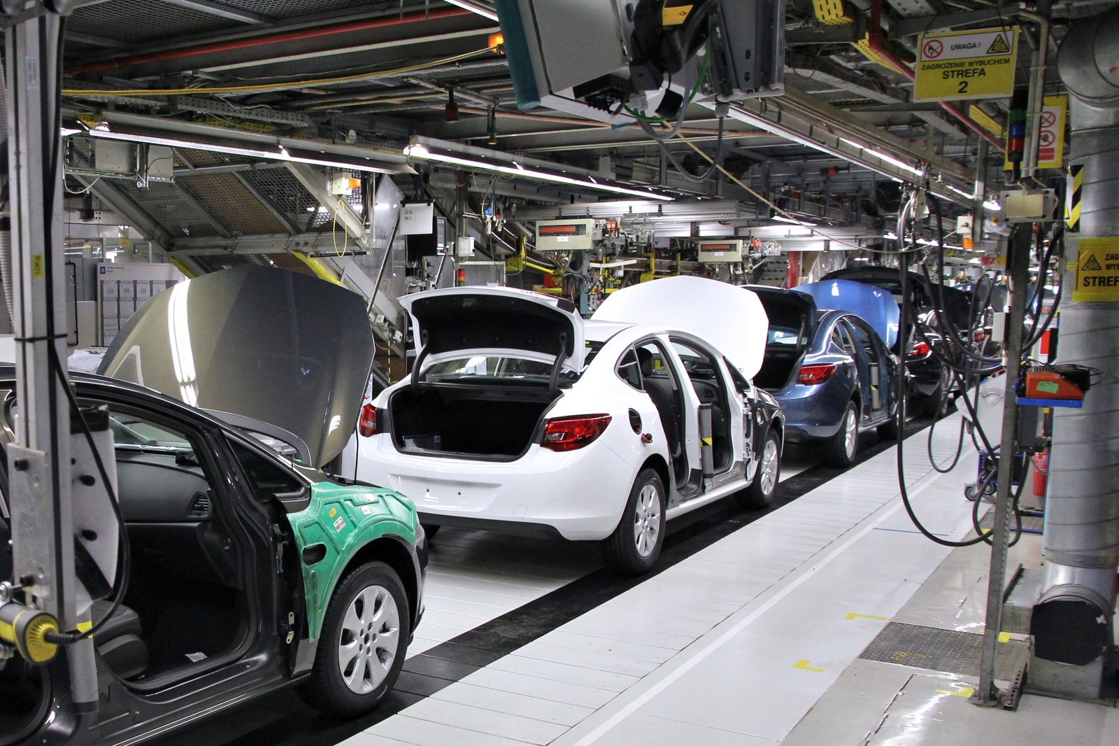 Vehicles moving down a modern automated automotive factory assembly line
