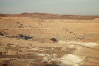 Panoramic view of an open-pit mineral extraction mine with terraced haul roads