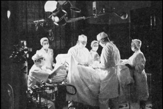 Inside a modern hospital surgical operating room with overhead lights and medical instrumentation