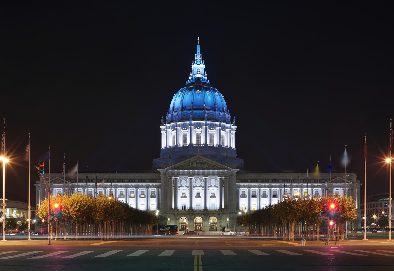 Neoclassical municipal city hall building with an illuminated dome at dusk